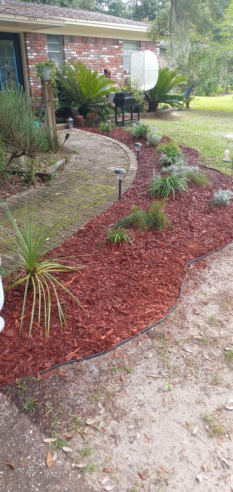 Landscaping — red mulch garden beds with curved brick walkway and path lights